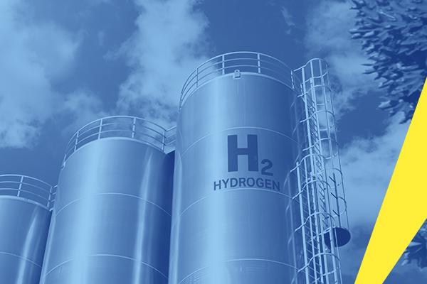 The photograph shows 3 large silver cylindrical hydrogen containers